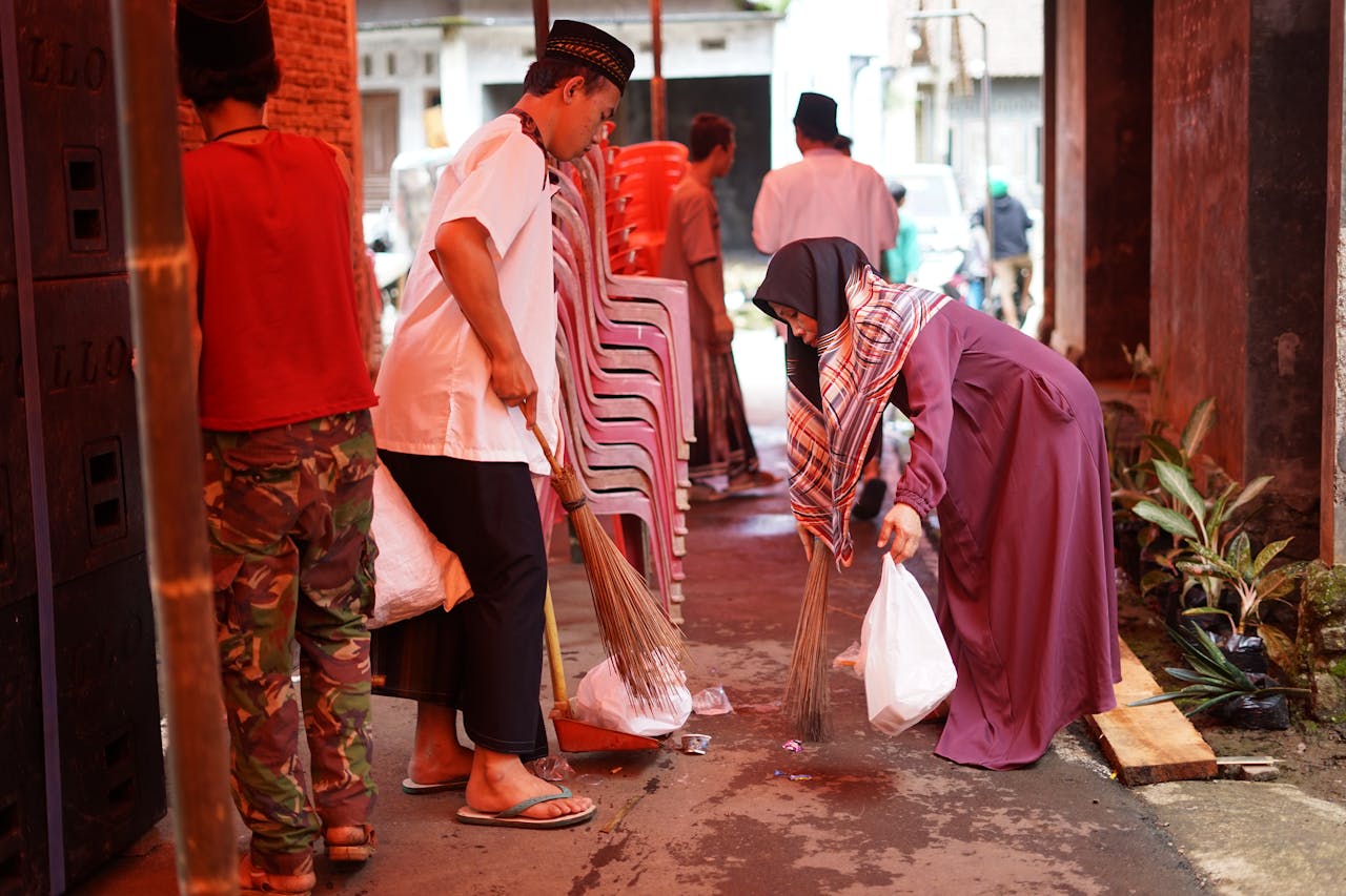 A group of people collaboratively cleaning an alleyway in a community event.